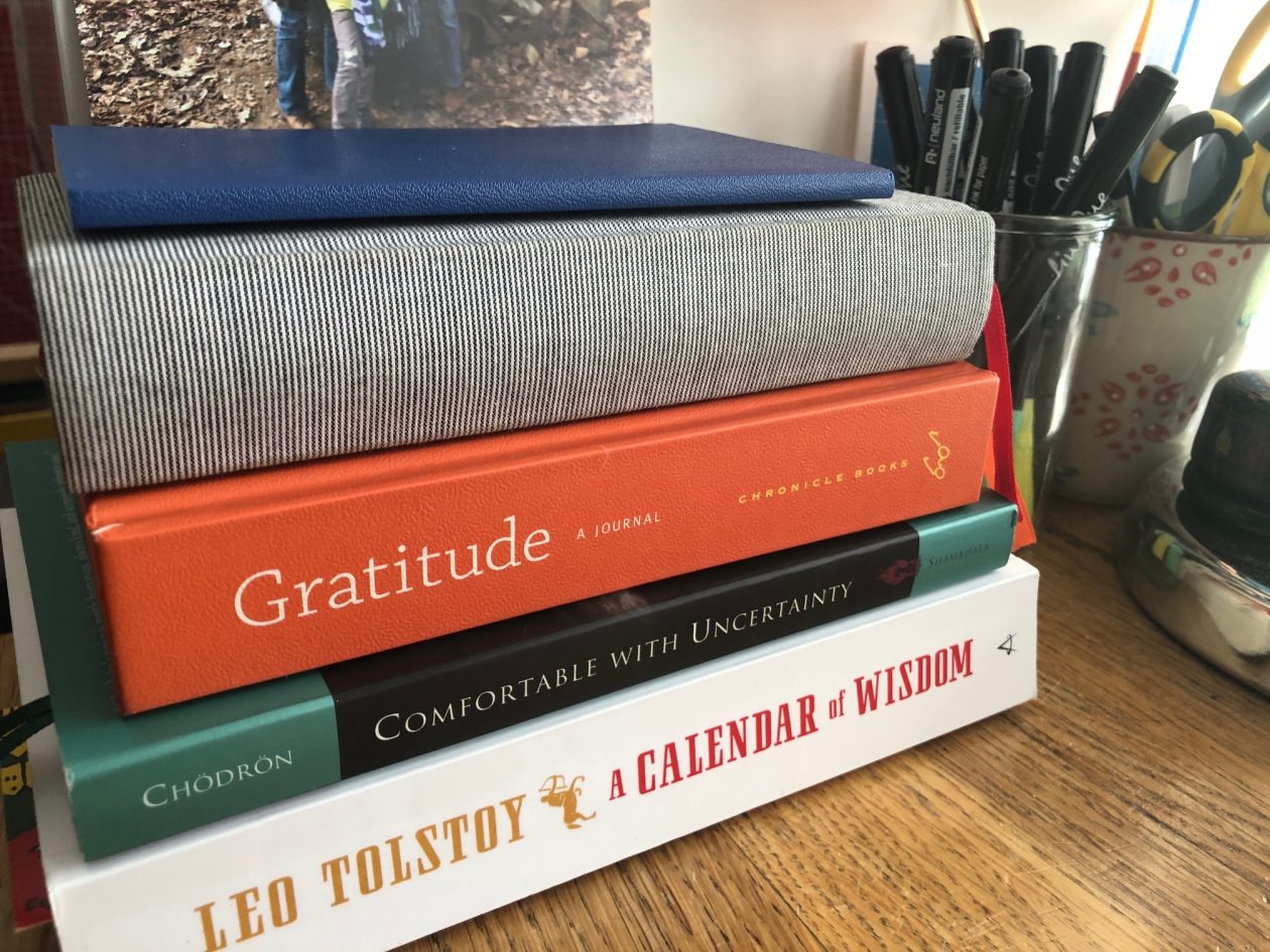 Five books piled up: Leo Tolestoy's Calendar of Wisdom, Pema Chodron's Comfortable with Uncertainty, a gratitude journal, a 5-year journal, and a small commonplace notebook